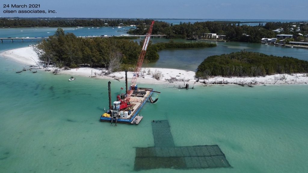 A photograph of the ongoing installation of rock-filled foundation mattresses offshore of Greer Island at the north end of Longboat Key, FL (photo March 24th, olsen associates, inc.)